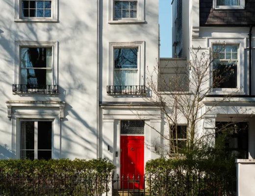 Townhouse mit weißer Fassade und roter Eingangstür in urbaner Lage