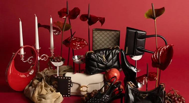 Luxus Geschenkidee mit Designer-Handtaschen, Accessoires und High Heels in festlicher roter Kulisse