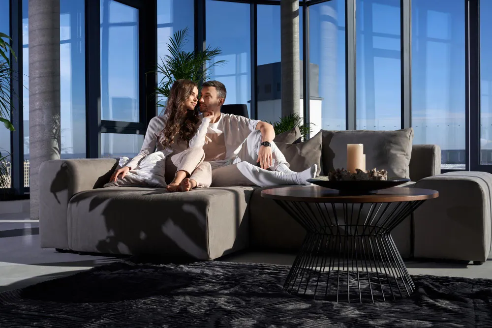 Paar in einem modernen Luxusapartment mit bodentiefen Fenstern und hochwertigem Interieur