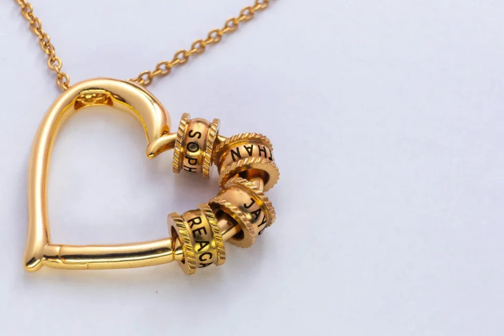 Personalisierter Schmuck – goldene Herz-Kette mit gravierten Namensringen