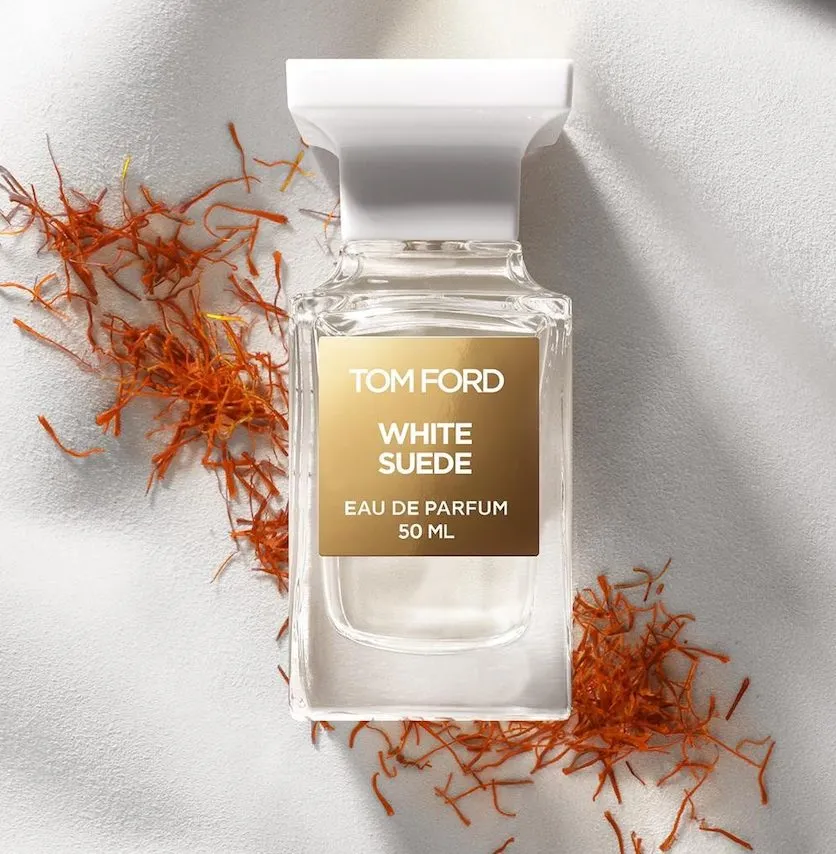 Tom Ford White Suede – klarer Flakon mit weißer Kappe auf hellem Untergrund, Safranfäden; dezenter, lederig-pudriger Luxusduft.