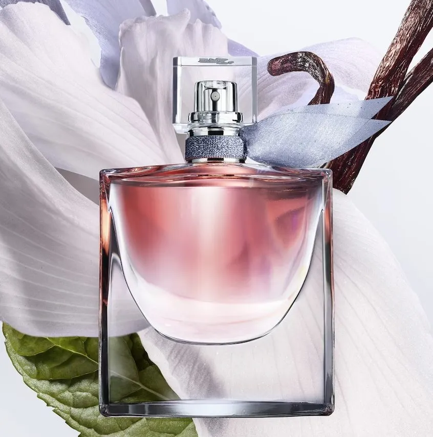 Lancôme „La Vie Est Belle“ – Glasflakon vor Blüten, Vanilleschote und grünem Blatt; elegantes Luxusparfum für Damen.