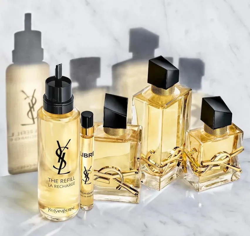 YSL Libre – Refill-Flakon, Travel-Spray und drei Größen des Parfums auf Marmor; goldene Flüssigkeit, schwarzer Verschluss, ikonisches YSL-Logo.