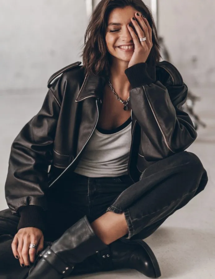 Braune Lederjacke f&uuml;r Damen im Oversize-Stil, l&auml;ssig kombiniert mit schwarzer Jeans und Boots