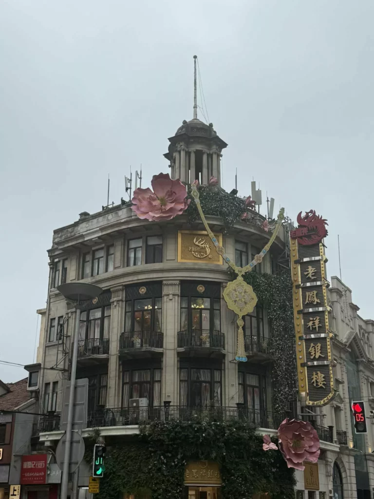 China Reise -Historisches Gebäude in Shanghai mit goldenen Verzierungen und floralen Elementen an der Fassade