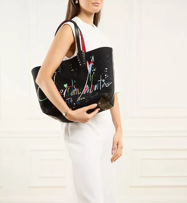 Schwarze Louboutin Tote Bag mit buntem Logo-Print, getragen zu weißem Outfit