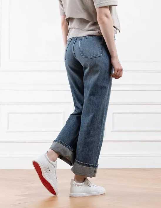 Weiße Louboutin Sneaker mit roter Sohle, getragen zu lässiger Jeans