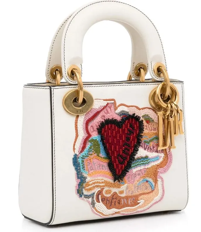 Lady Dior Mini in Weiß mit handbesticktem Herzmotiv im Niki-de-Saint-Phalle-Stil, goldfarbener Hardware und Cannage-Steppung.