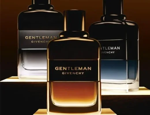 Drei Givenchy Gentleman Parfumflakons 2025 – amberfarbene, graue und blau-schwarze Duftvariante auf beleuchteten Podesten