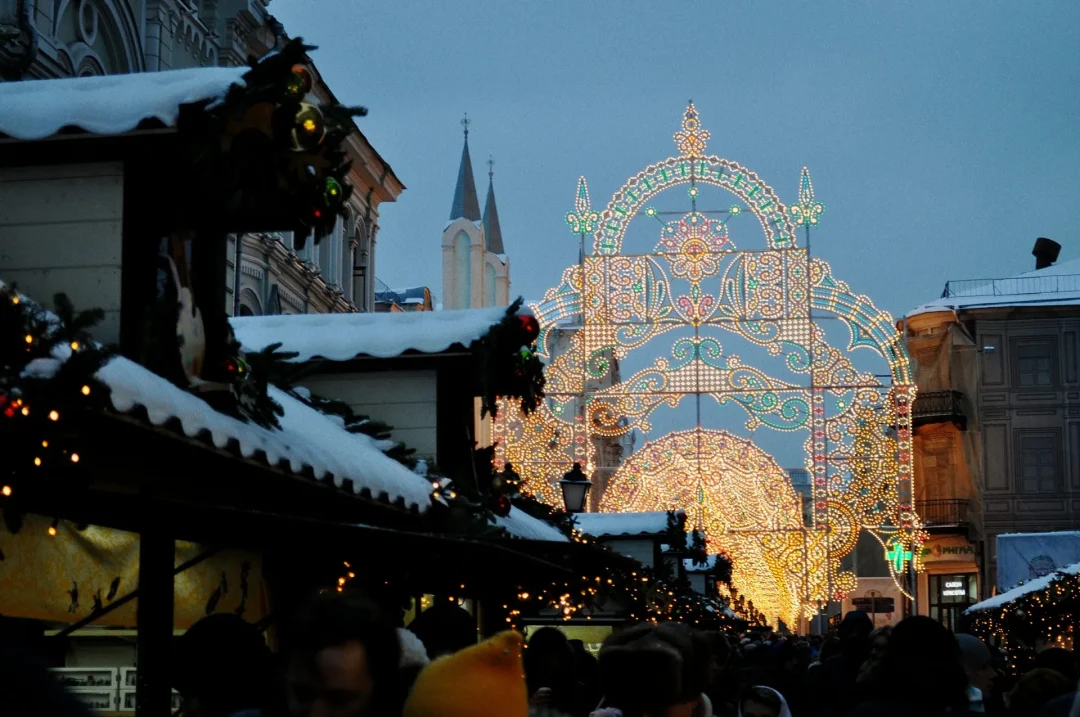 Christkindlesmarkt Nürnberg bei Abenddämmerung – festlich beleuchtete Buden und großer Lichterbogen in der Altstadt