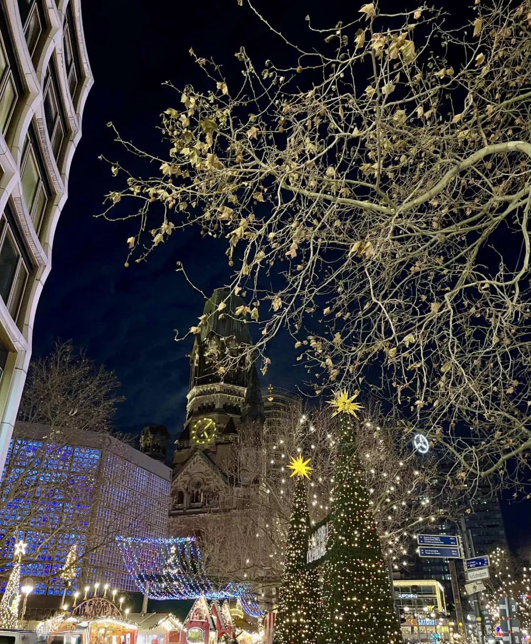 Weihnachtsmarkt an der Gedächtniskirche mit festlich geschmückten Tannen bei Nacht – Weihnachtsmarkt Berlin 2025