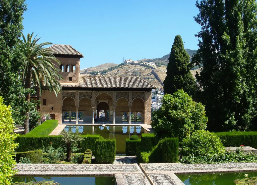 Maurischer Palastgarten der Alhambra in Granada, Spiegelbecken, Arkaden und Zypressen – mediterrane Architektur und Gartenkunst.