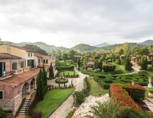 Exklusive Immobilien in Italien – mediterrane Villa im italienischen Stil mit formalem Garten, Zypressen und Blick auf grüne Hügellandschaft.