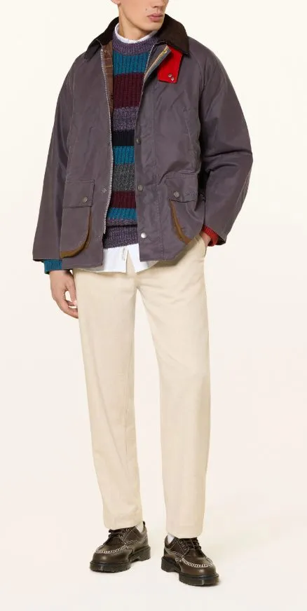 Herren-Outfit mit klassischer Barbour Jacke, gestreiftem Strickpullover und heller Stoffhose