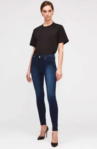 Model trägt dunkelblaue Skinny Jeans mit schwarzem T-Shirt und Pumps – eleganter Denim-Look