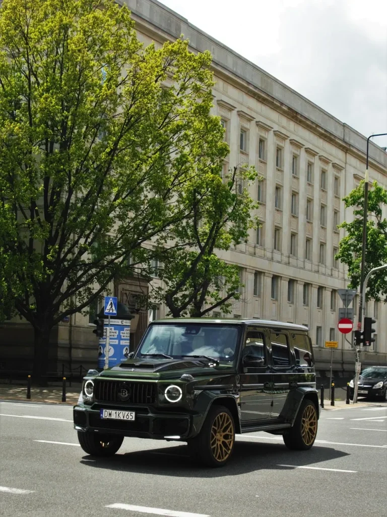 Mercedes Brabus G-Klasse als veredeltes Luxus-SUV mit schwarzem Lack und goldfarbenen Leichtmetallfelgen im Stadtverkehr