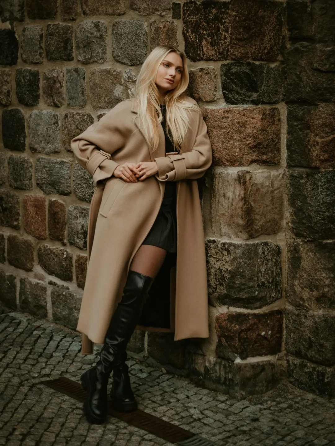 Overknee-Stiefel in Schwarz kombiniert mit beigem Wollmantel und Minirock