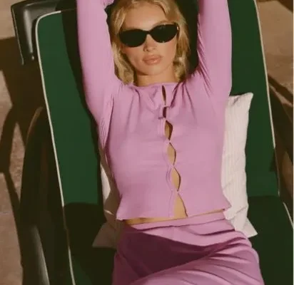 Elsa Hosk in rosafarbenem Alo Set entspannt auf Sonnenliege, moderner Valentinstagslook