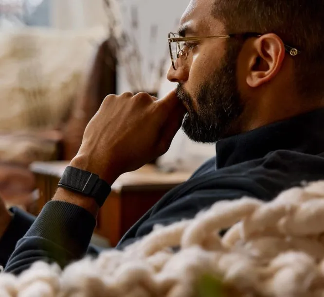 Mann tr&auml;gt den Health Tracker WHOOP 5.0 am Handgelenk und reflektiert ruhig seine Gesundheitsdaten im Alltag