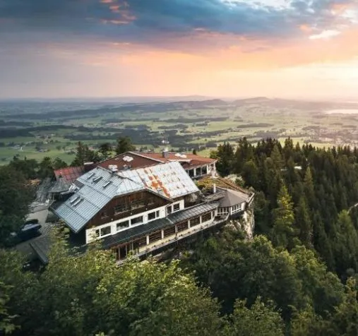Blaue Burg Boutiquehotel auf dem Falkenstein in Pfronten mit Panoramablick über das Allgäu bei Sonnenuntergang