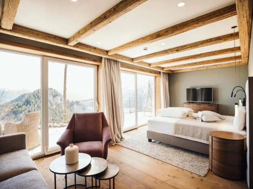 Suite der Blauen Burg im Allgäu mit Panoramafenster, Holzbalkendecke und Blick auf die Alpen