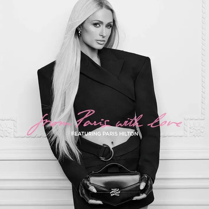 Paris Hilton für Karl Lagerfeld in der SS26-Kampagne 2026 mit schwarzem Blazer und Signature-Tasche im Pariser Maison