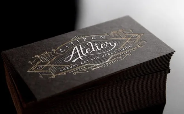 Luxuriöse Visitenkarten mit Goldprägung auf dunklem Strukturkarton in hochwertiger Verarbeitung