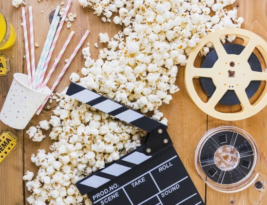 Popcorn, Filmklappe und Filmrollen auf Holztisch – Symbolbild für Berlinale 2026 und Filmfestival in Berlin