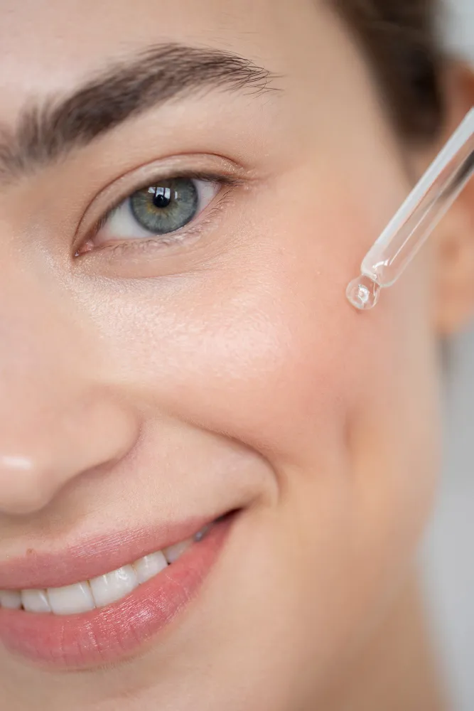 Frau mit glatter Haut trägt Serum mit Pipette auf – Botox Alternative Skincare
