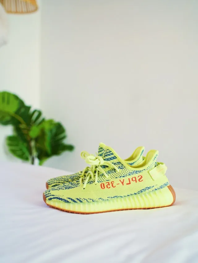 Adidas Yeezy Boost 350 V2 Sneaker in Neon gelb als Beispiel für limitierte und wertvolle Sneaker ModelleFoto von <a href="https://unsplash.com/de/@cspek?utm_source=unsplash&utm_medium=referral&utm_content=creditCopyText">Chris Nguyen</a> auf <a href="https://unsplash.com/de/fotos/gefrorene-gelbe-adidas-yeezy-boost-v2s-auf-weisser-tagesdecke-qK7fGCftQi0?utm_source=unsplash&utm_medium=referral&utm_content=creditCopyText">Unsplash</a>