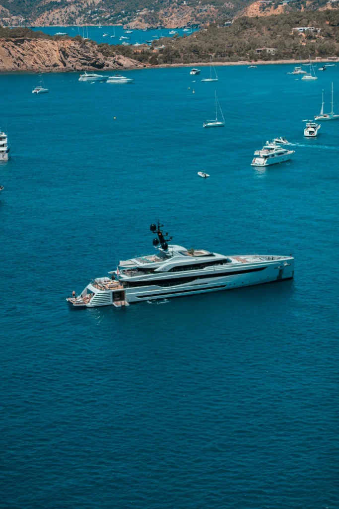 Luxusyacht in türkisblauem Meer vor einer mediterranen Küstenlandschaft