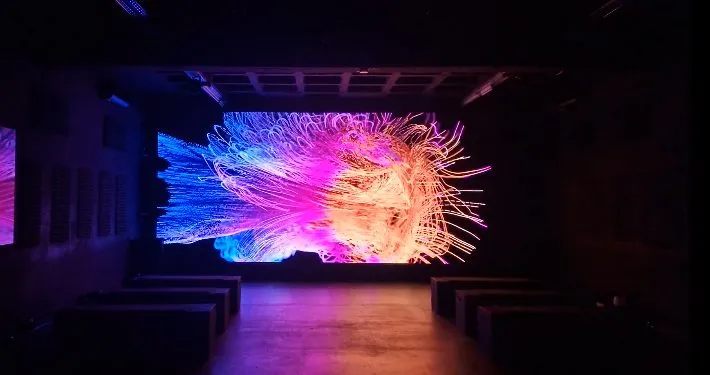 Digitale Kunstinstallation in der P61 Gallery Berlin mit leuchtenden neonfarbenen Formen auf einer großformatigen LED-Wall