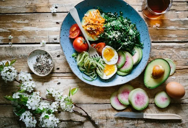 Schale mit frischem Gemüse, Ei, Avocado und Blattgemüse als Beispiel für eine ausgewogene Longevity-Ernährung.