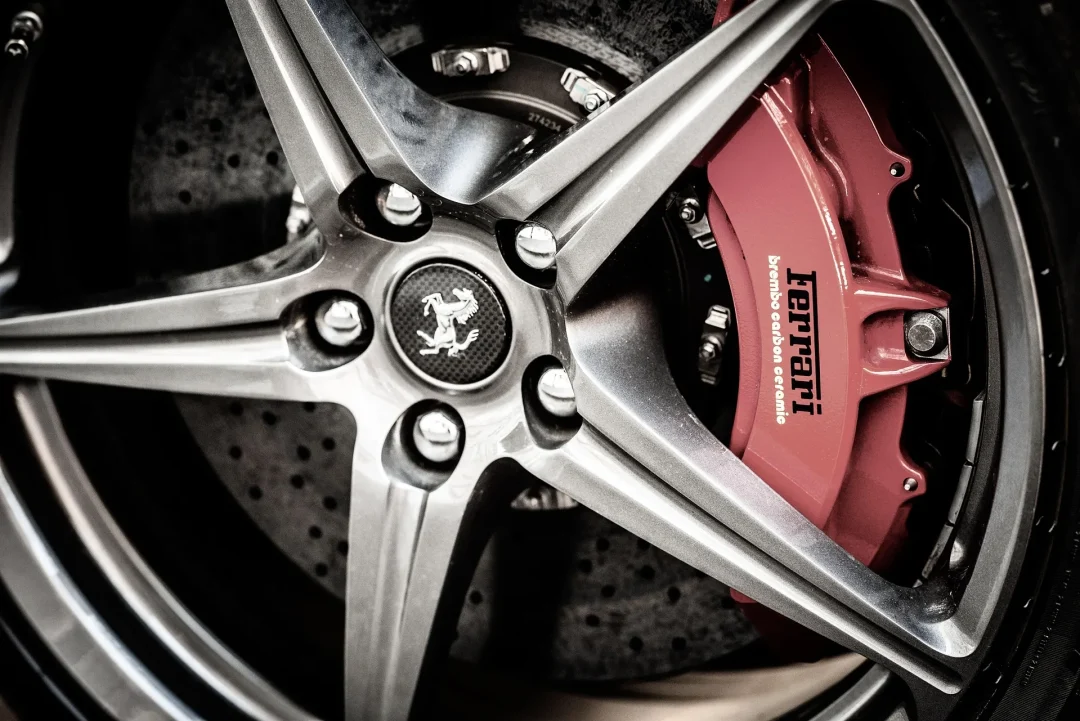 Detailaufnahme der Carbon-Keramik-Bremsanlage eines Ferrari 599XX Evo mit Brembo-Bremssattel und Ferrari-Logo