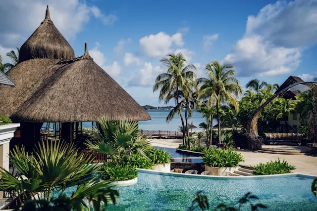 Luxusresort auf Mauritius mit tropischer Gartenanlage, Infinity-Pool, Palmen und Blick auf die Lagune.