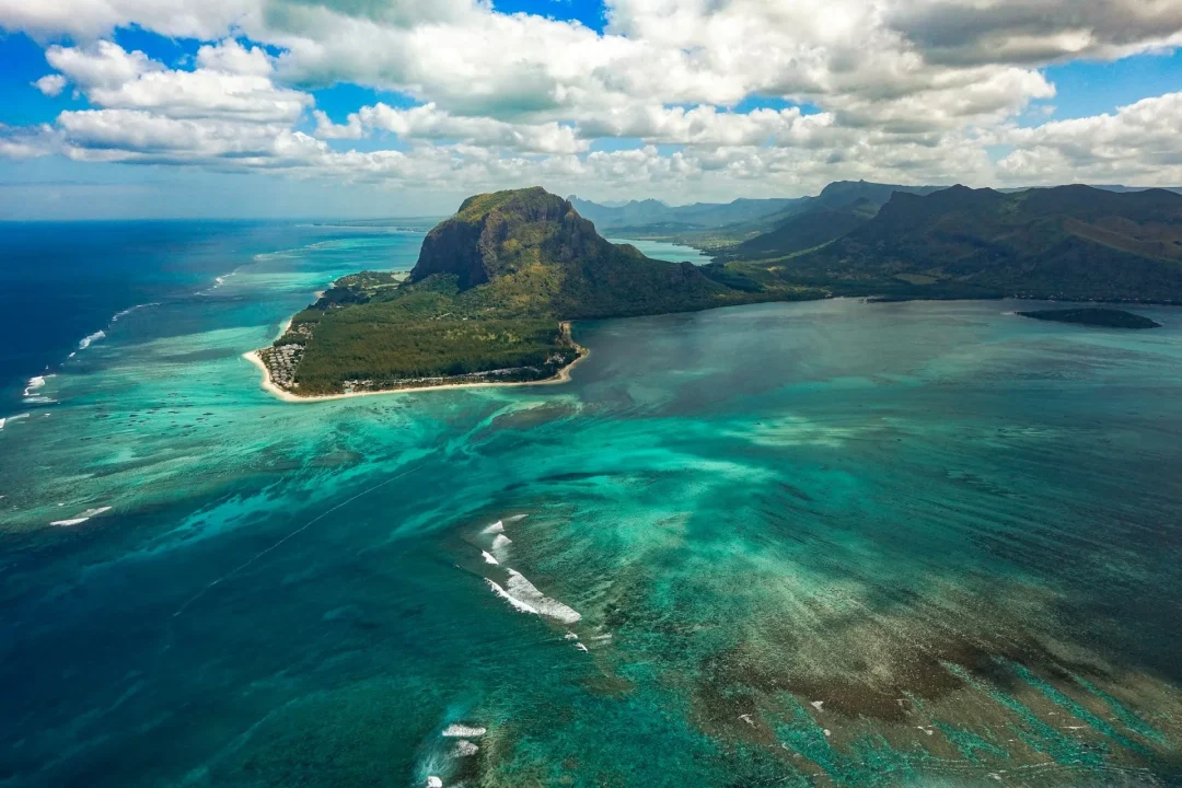 Luftaufnahme der Südwestküste von Mauritius mit dem markanten Le Morne Brabant, türkisfarbener Lagune und Korallenriffen im Indischen Ozean.