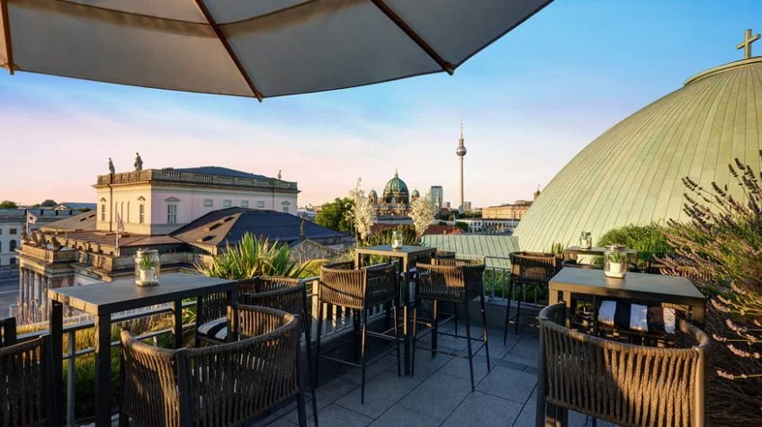 Dachterrasse des Hotel de Rome mit Sitzplätzen und Blick auf Berliner Dom, Fernsehturm und die Dächer von Berlin-Mitte