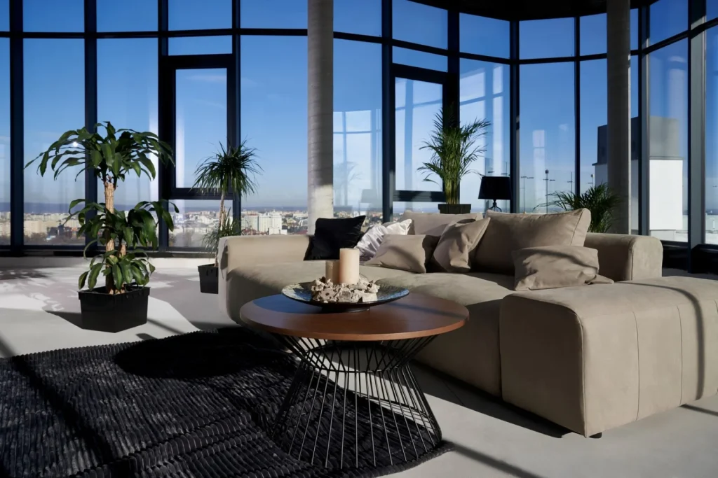 Beige Sofa und schwarzer Drahtgittertisch im modernen Wohnzimmer mit Panoramafenstern