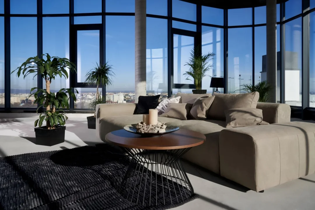 Beige Sofa und schwarzer Drahtgittertisch im modernen Wohnzimmer mit Panoramafenstern