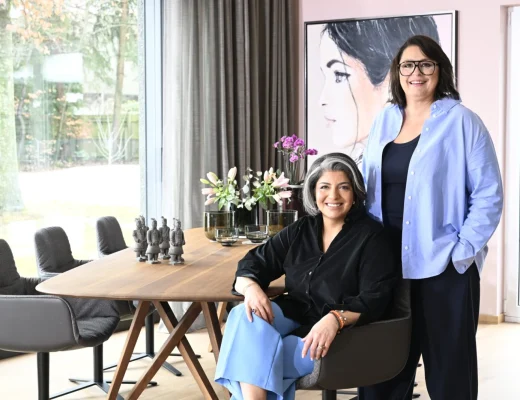 Sophia Lauton und Sahar Essmann im hellen Showroom mit Holztisch und grauen Sesseln