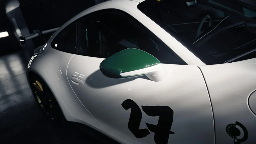 Grüner Außenspiegel und schwarze Startnummer 27 am Porsche 911 GT3 100 Jahre Nürburgring