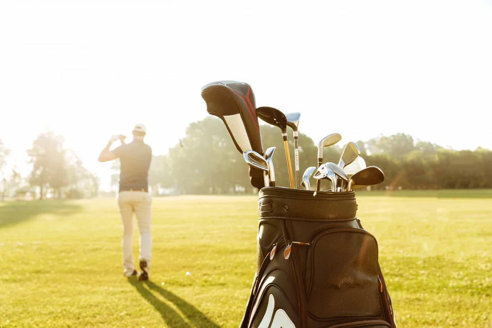 Golfbag mit Schl&auml;gern und Golfer auf einem Golfplatz