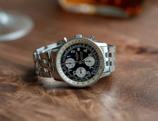 Breitling Navitimer Chronograph mit schwarzem Zifferblatt und Edelstahlarmband auf einem Holztisch
